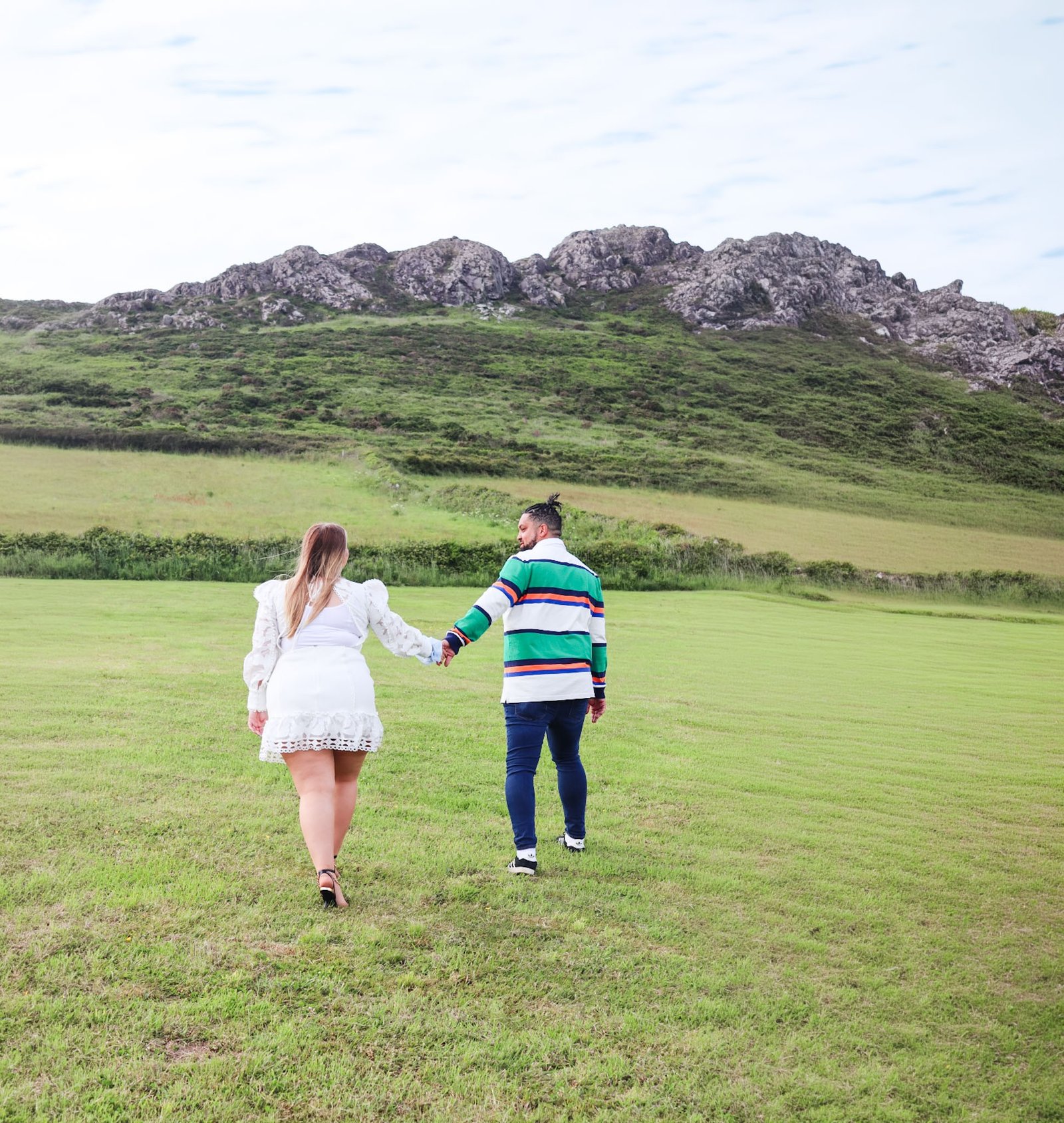 Engaged couple walking together through the countryside