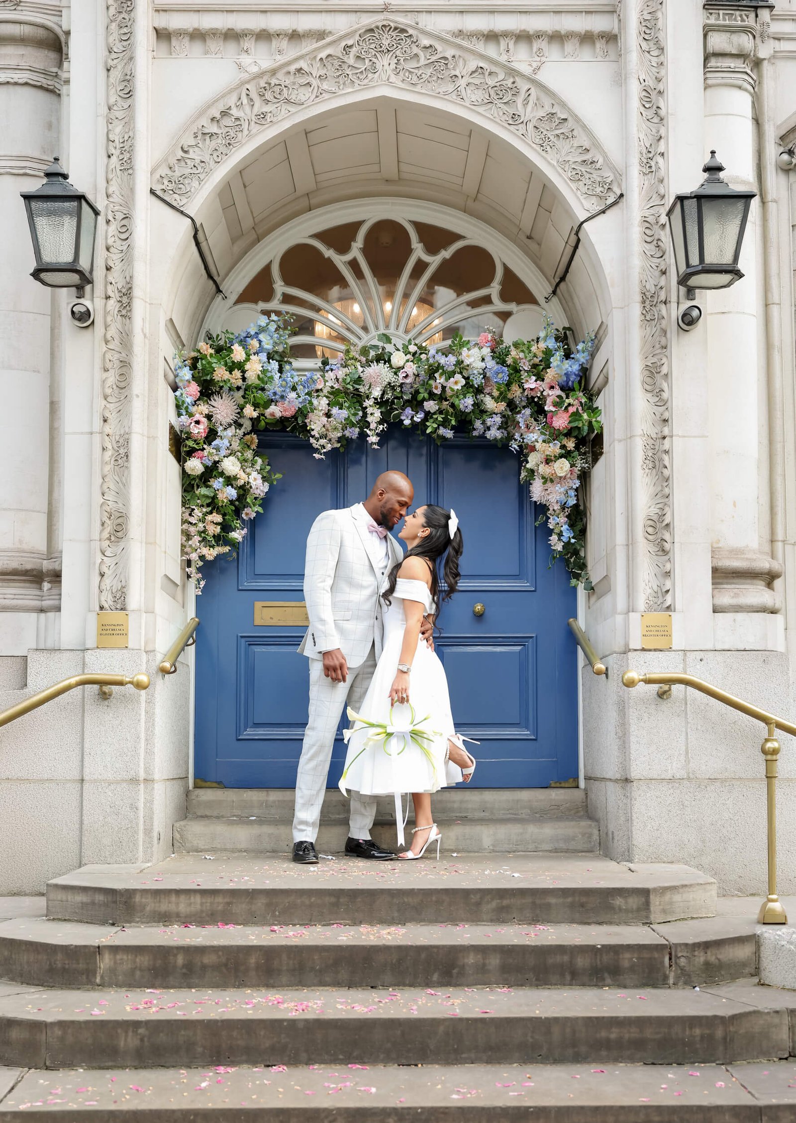 Newlywed couple outside a London venue decorated with wedding flowers